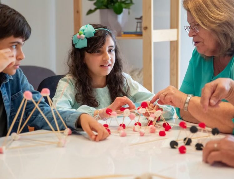 Grandmother playing educational games with grandchildren indoors, fostering creativity and learning.